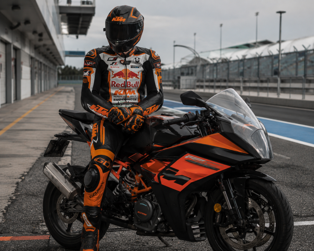 KTM Motorcycle Racing Suit on Rider | Go Max Racing Professional rider wearing the Go Max Racing KTM Motorcycle Racing Suit on a sportbike at a racing circuit.